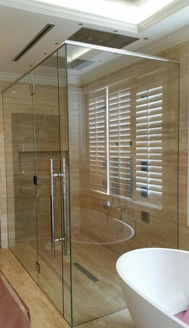 Frameless shower beside a freestanding tub