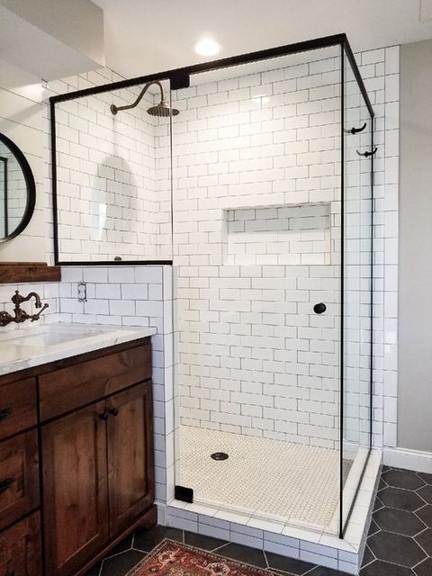 Frameless shower with black hardware and white subway tile