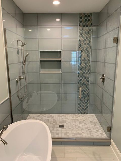 Frameless corner shower beside a freestanding tub