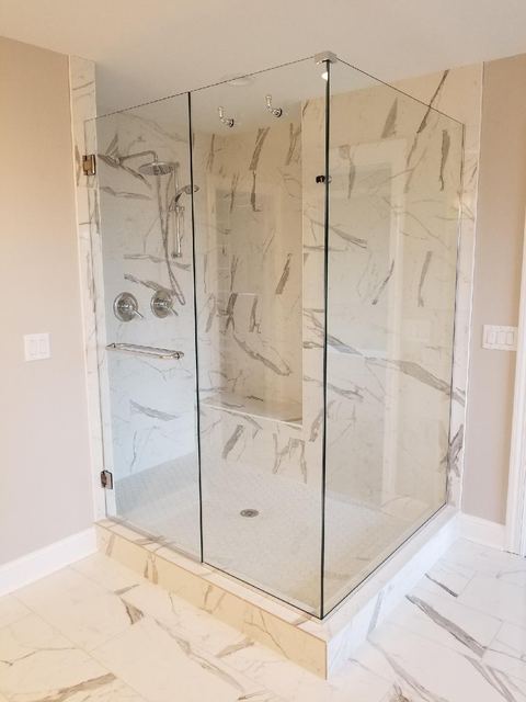 Frameless corner shower in a marble bathroom