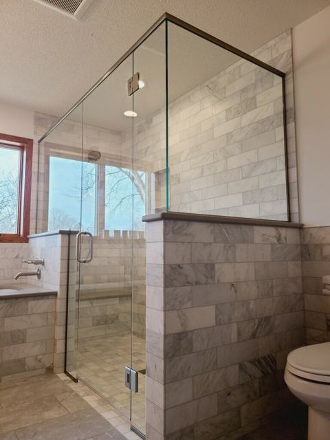Frameless corner shower on a stone half wall