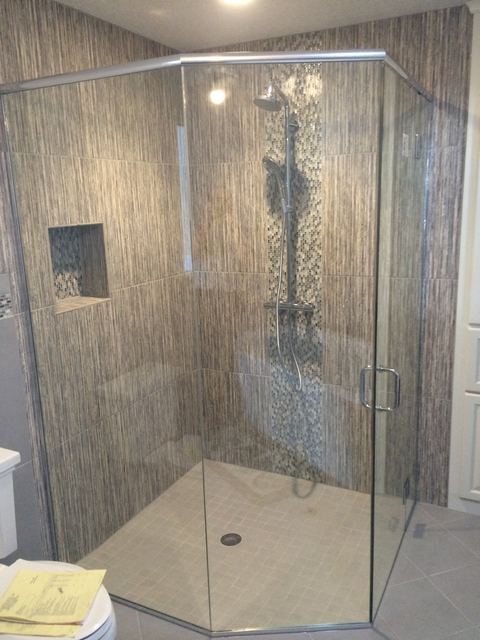 Frameless neo-angle shower with stone tile