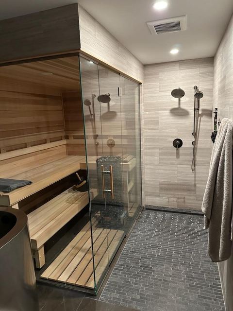 Frameless shower next to a cedar sauna