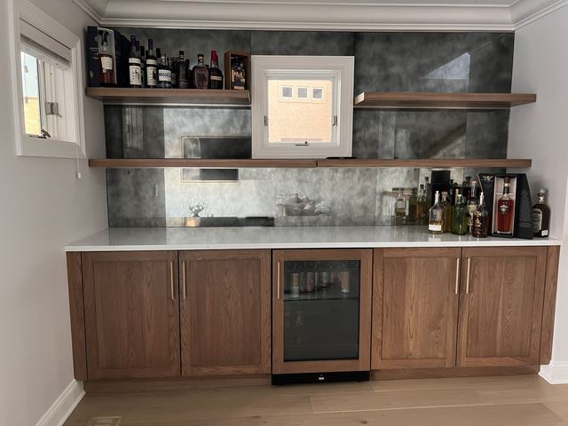Home bar with an antique mirror backsplash behind floating shelves