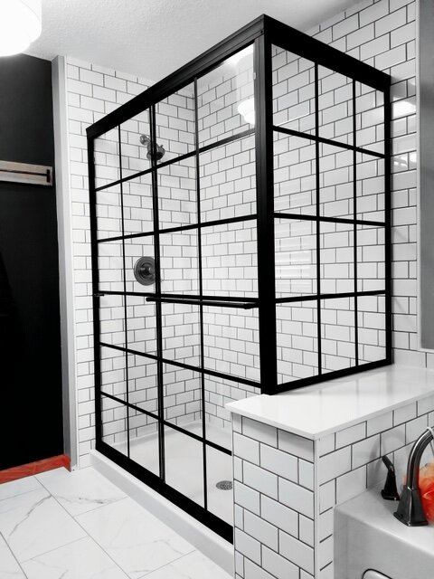 Black grid-pattern shower enclosure with white subway tile
