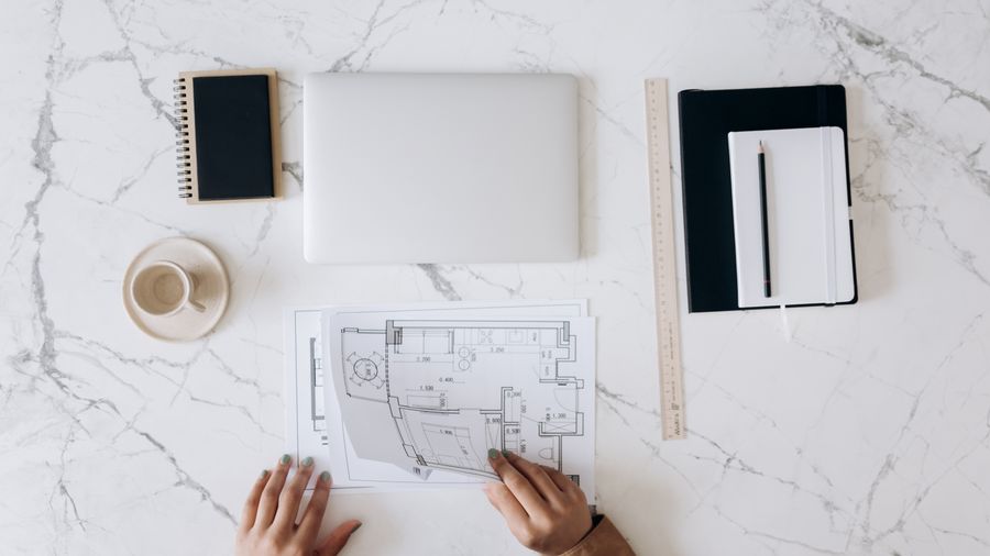 Architect's desk with a floor plan and drafting tools