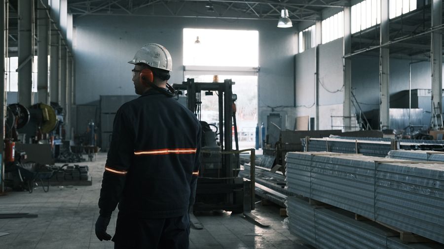 Worker moving stacked panels in a fabrication shop