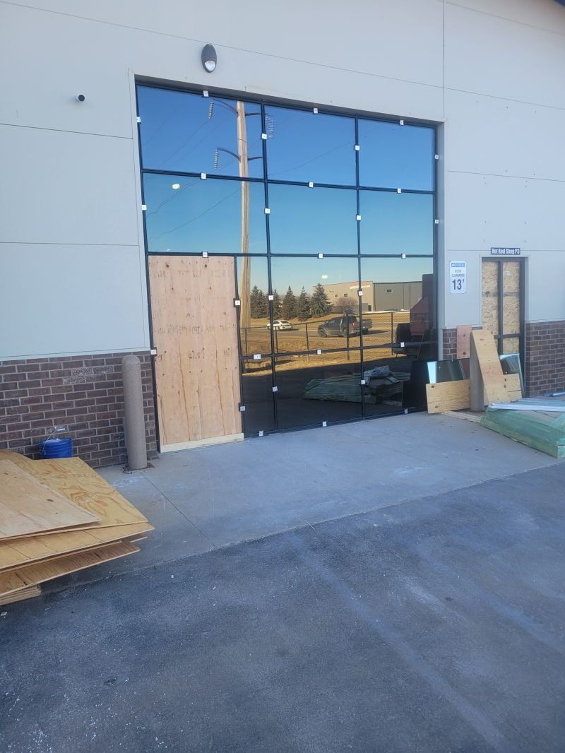 Dark-framed storefront window wall on a new commercial building